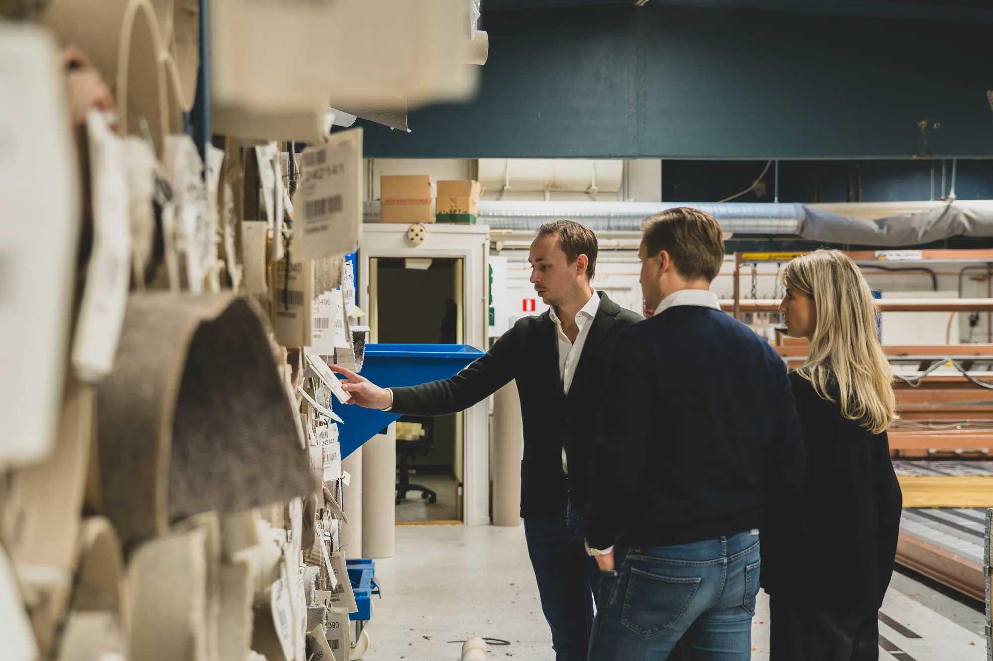 Tre personer tittar på materialprover i Golvabias produktionsmiljö.