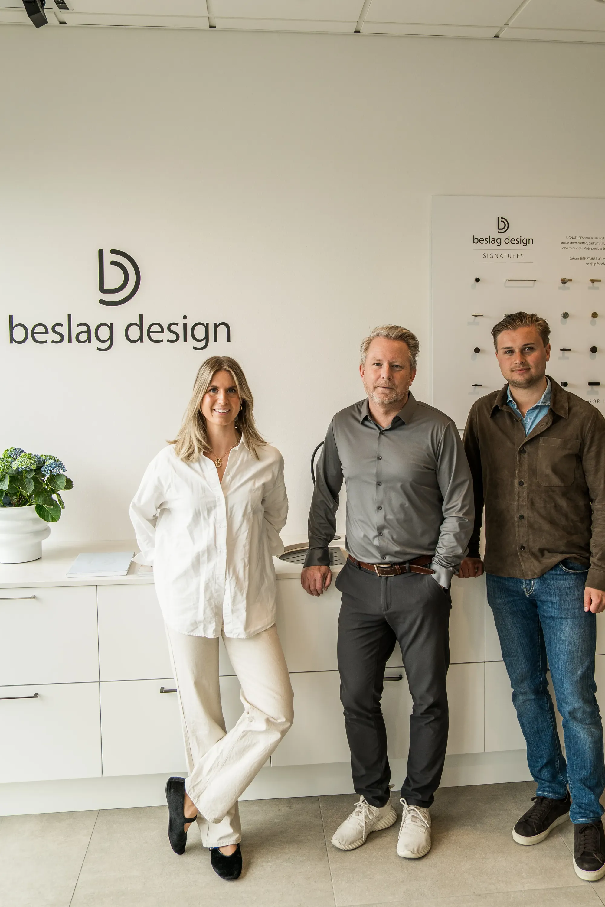 Mirjam Lewin, Pontus Eklind och Oscar Salomonsson framför Beslag Designs logotyp.