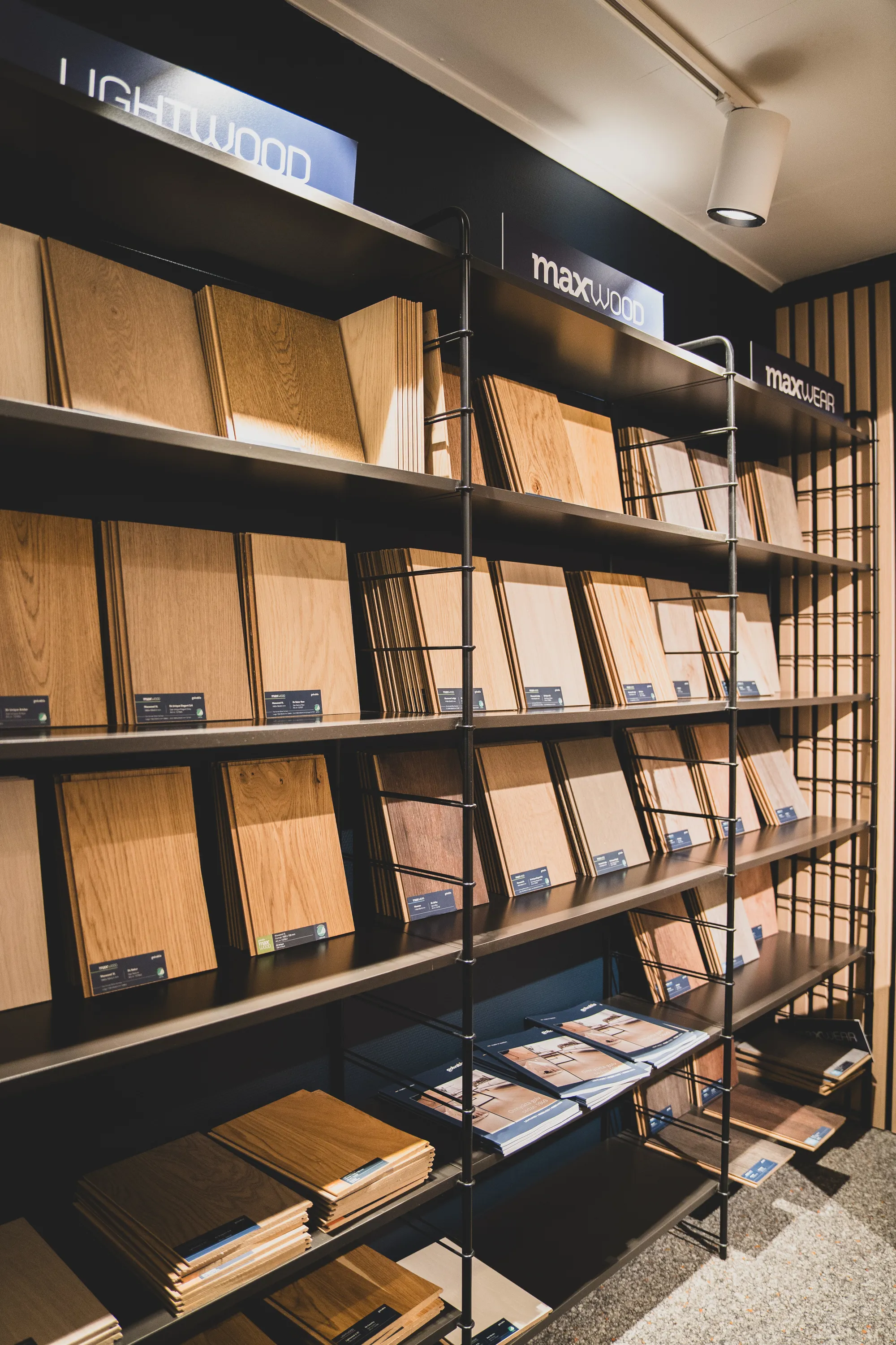Hylla med träprover i flera nyanser och ådringar i Golvabias butik.
