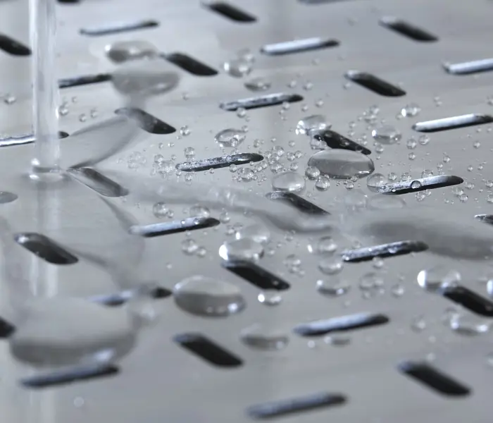 Vatten som droppar på en golvbrunn i rostfritt stål från Furhoffs Rostfria