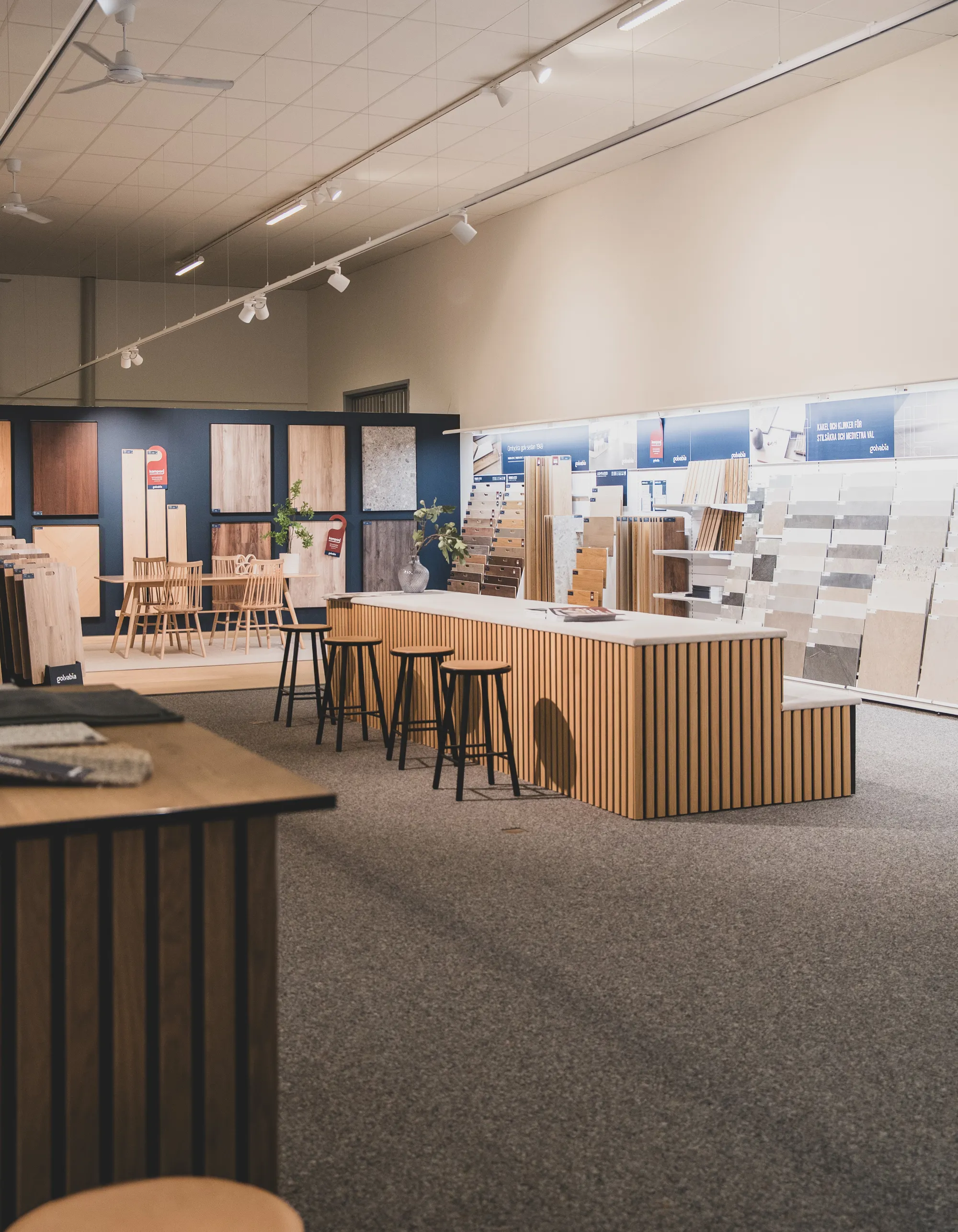 Showroom med golv- och kakelprover uppställda för visning.